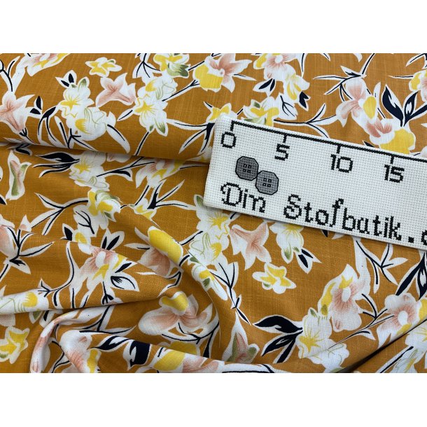Fast viskose med lidt strk og hr look, gylden gul bund med blomster. 110 kr pr m