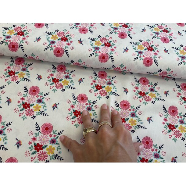 Fast 100 % bomuld, hvid bund med klart blomster print i rde farver. 69 kr pr m.