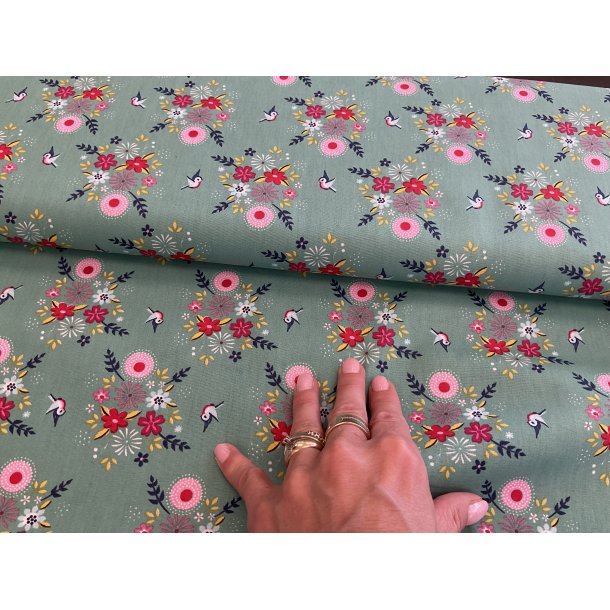 Fast 100 % bomuld, grn bund med smukke rde blomster. 69 kr pr m.
