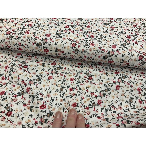 Fast 100 % bomuld tt vvet, hvid bund med bitte sm fine blomster i rde farver. 75 kr pr m